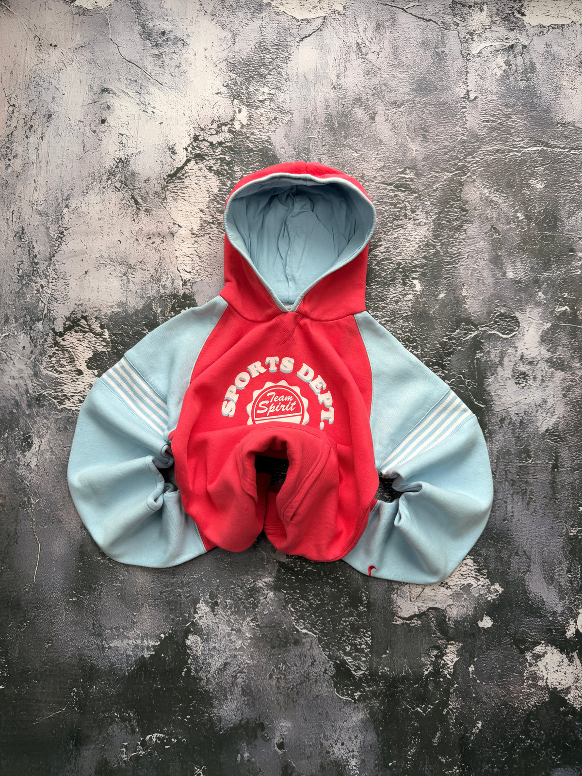 Bluza Nike Sports Dept. czerwona z błękitnymi rękawami i kapturem — zdjęcie główne, bluza złożona w bombkę