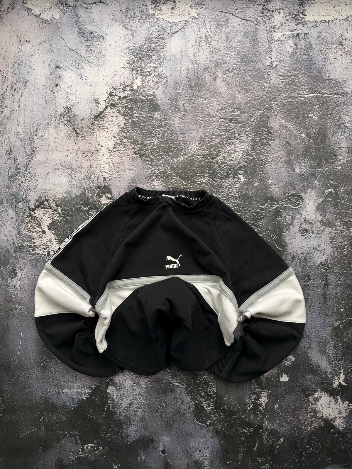 Bluza Puma czarna z jasnym panelem — zdjęcie główne, bluza złożona w bombkę