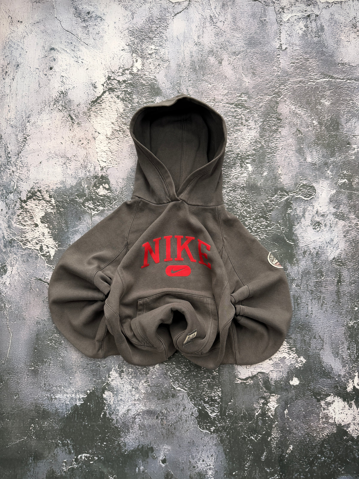 Bluza Nike oliwkowa z czerwonym logo i kapturem — zdjęcie główne, bluza złożona w bombkę