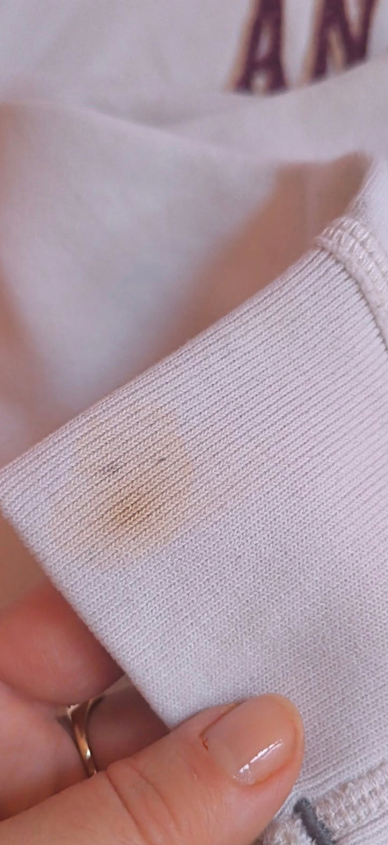 Kremowa bluza Abercrombie & Fitch — zbliżenie widocznej plamy na mankiecie