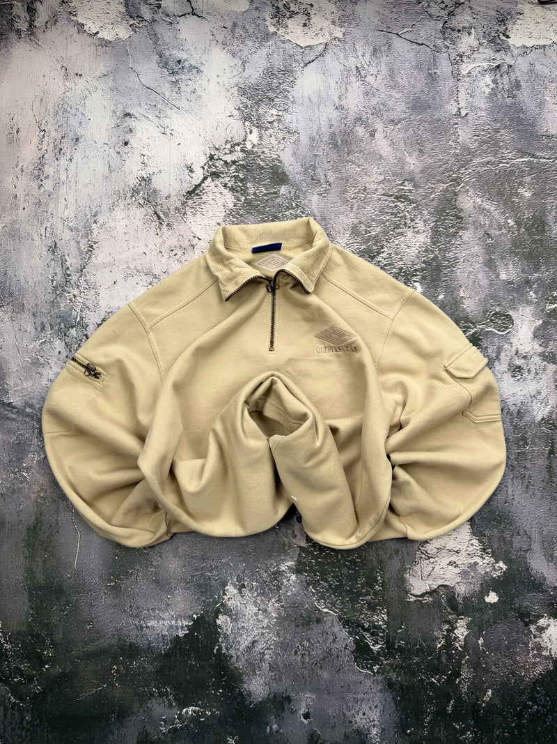 Bluza Umbro beżowa z kołnierzem, krótkim zamkiem i kieszonką na rękawie – krój prosty — centralne